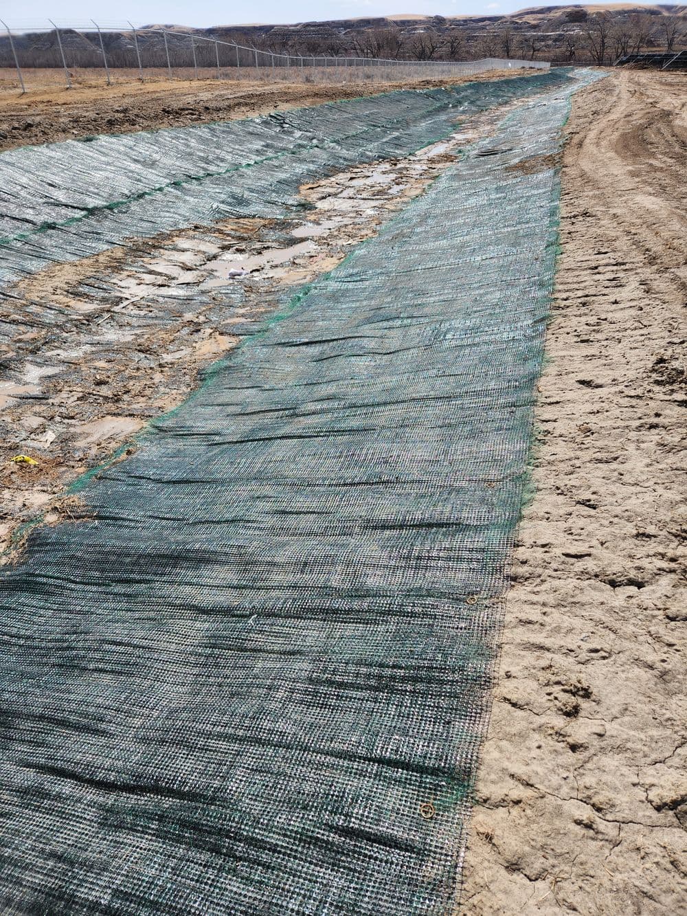 Erosion control mesh installed along a drainage ditch